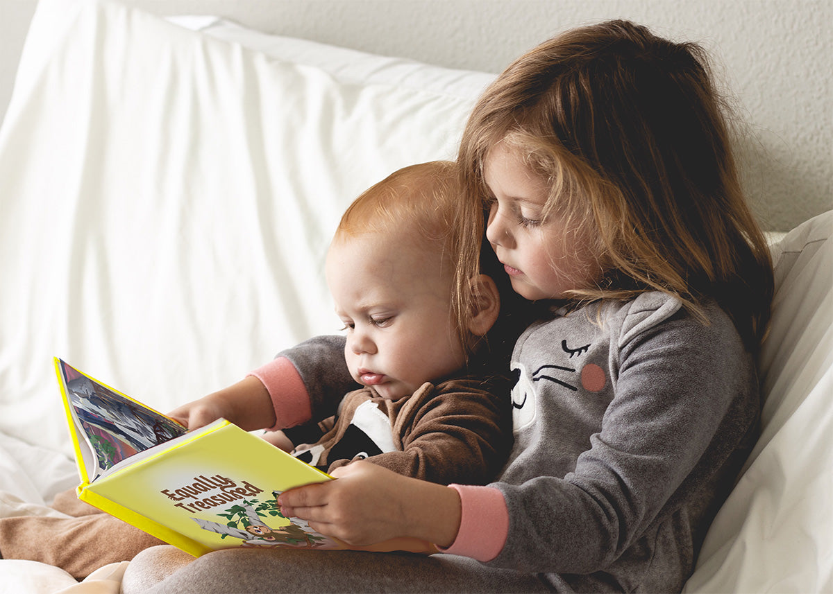 big sister reading "equally treasured" christian children's storybook by shelby cohen, illustrated by steven cohen