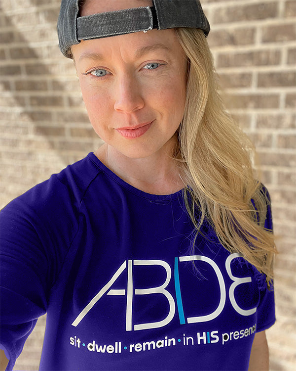 Two models against a brick wall wearing Now Found Apparel's Onyx Black ABIDE Bamboo shirts and Black Out Trucker caps.