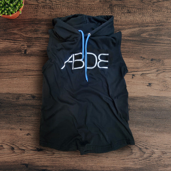 Black sleeveless hoodie with 'ABDE' text on a wooden surface
