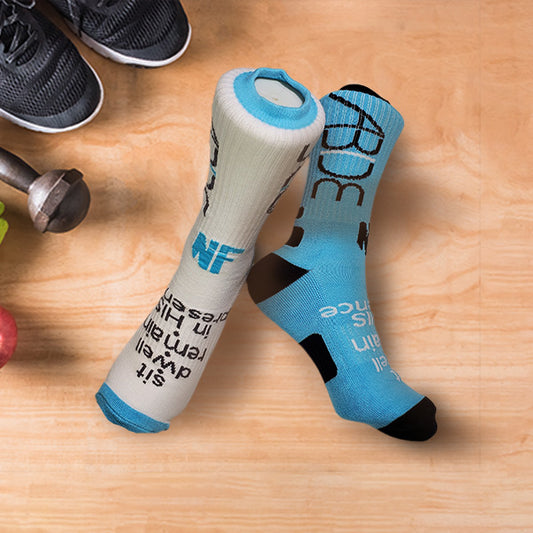 Active crew socks with ABIDE sit - dwell - remain in His presence design on a wooden surface, with shoes and a dumbbell in the background.