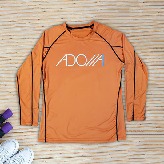 Orange long-sleeve athletic shirt with 'ADONAI' logo on a wooden surface