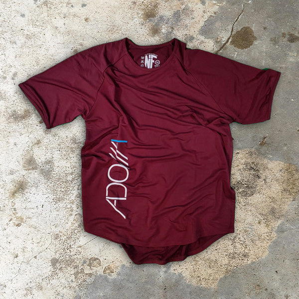 Maroon t-shirt with 'ADONAI (Lord)' logo on a concrete surface