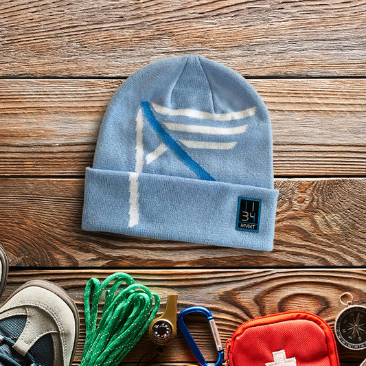 Blue I AM (YHWH) Christian beanie on a wooden surface with outdoor gear
