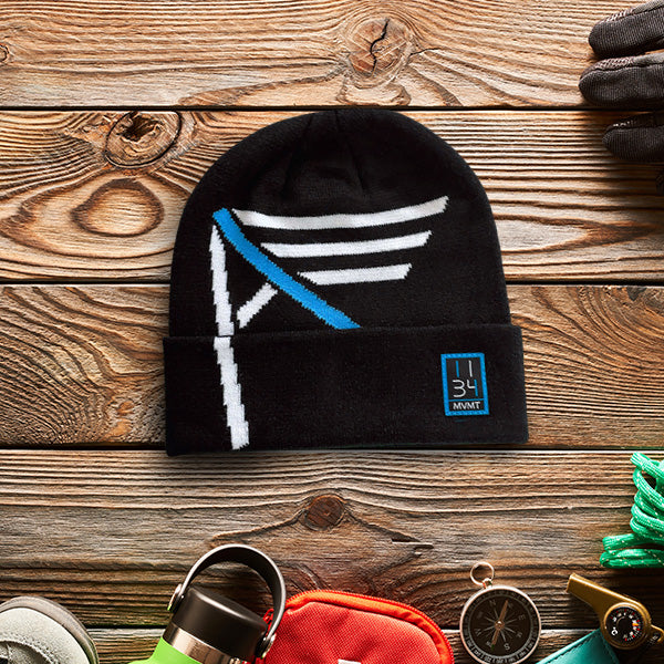 Black beanie with a white and blue Christian I AM logo design with 1134 on a wooden surface