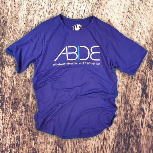 Blue ABIDE Bamboo Christian Tee on a wooden surface