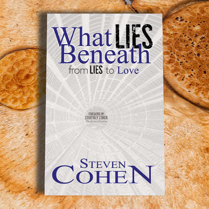 Book titled 'What Lies Beneath: From Lies to Love' by Steven Cohen on a wooden surface.