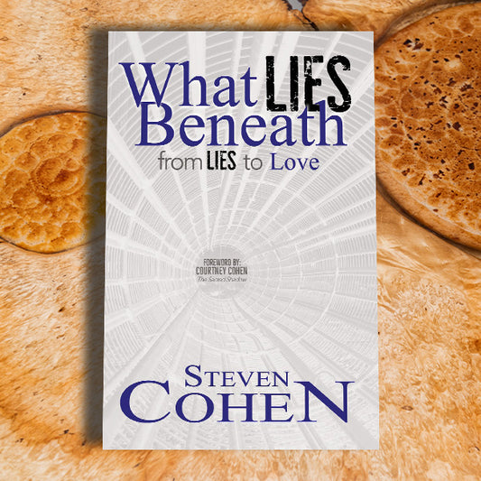 Book titled 'What Lies Beneath: From Lies to Love' by Steven Cohen on a wooden surface.